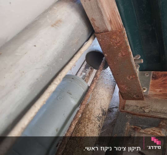 צינור פלסטיק אפור עם חיבורים חלודים